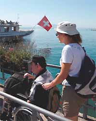 bénévole accompagnant un handicapé au bord du lac Léman 