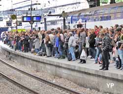 la foule attend un train en retard à Saint-Lazare